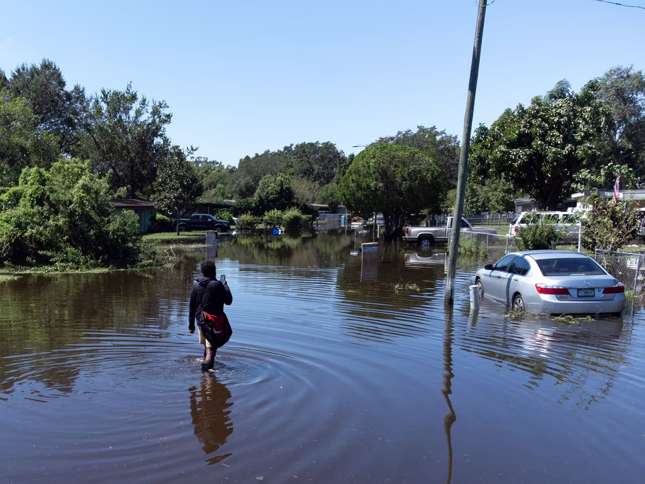 A man walks through a flooded street in the Orlovista neighborhood following Hurricane Ian on October 1, in Orlando, Florida. 