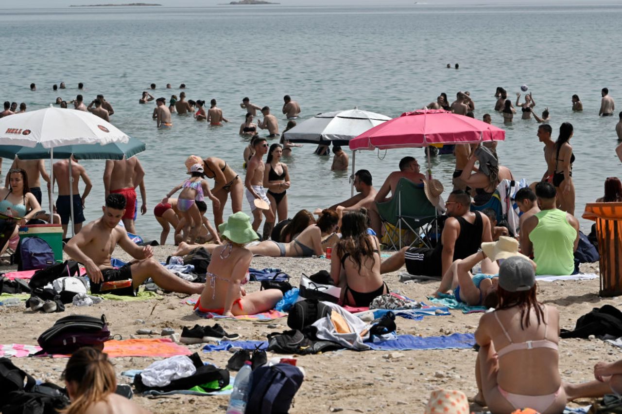 Beachgoers enjoy the sun and sea at public beach during the official reopening of beaches to the public on May 16 in Varkiza, Greece.?