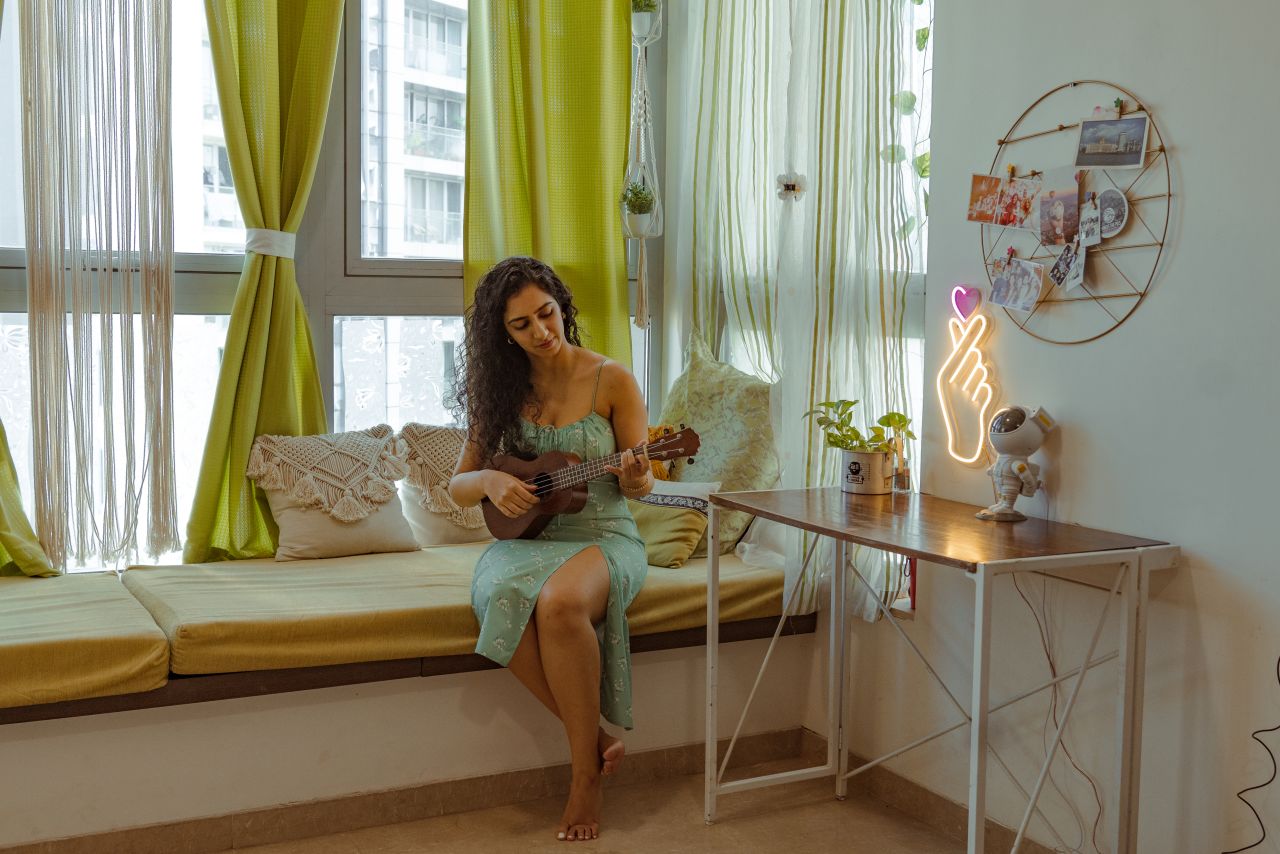 Verma plays the ukulele inside her bedroom.