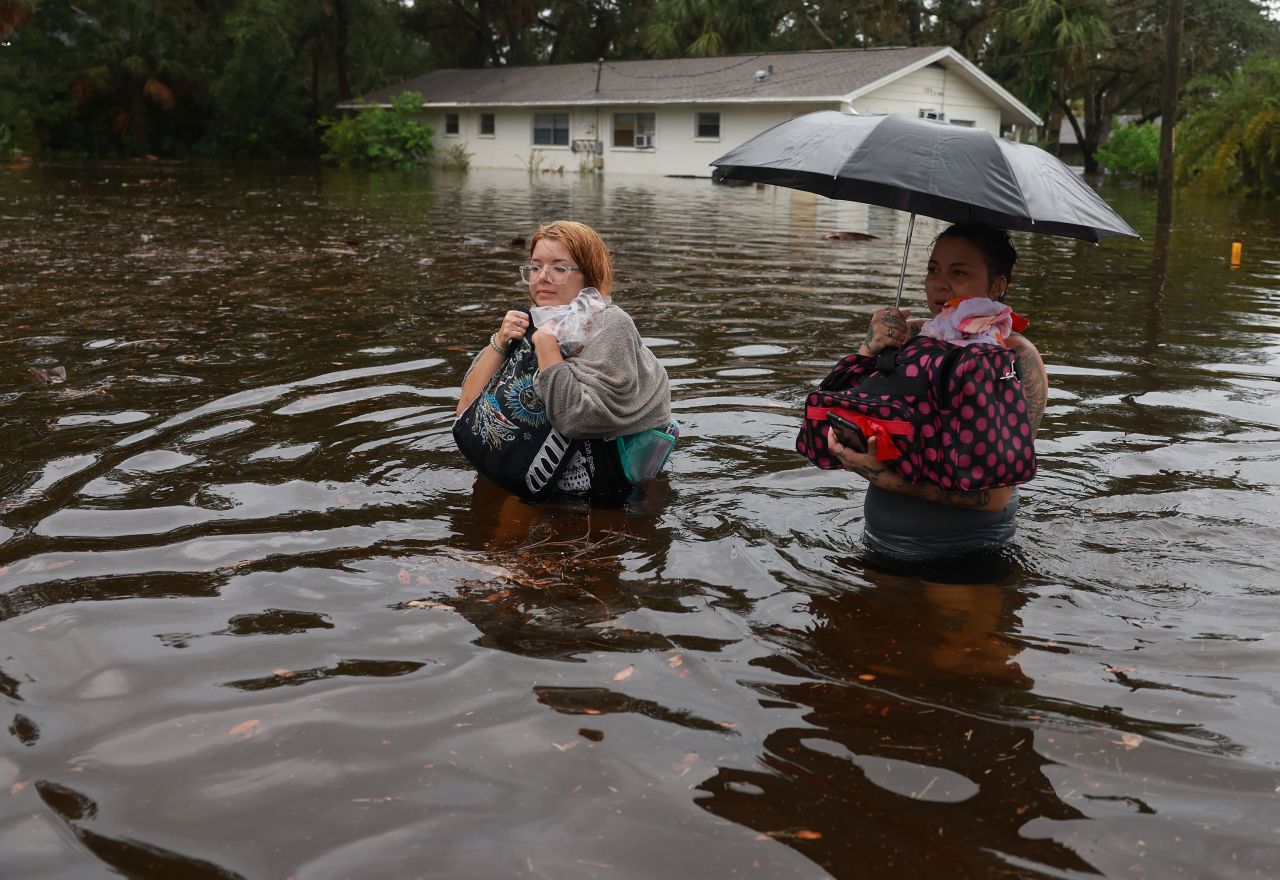 Makatla Ritchter, left, and her mother Keiphra Line wade through flood waters after having to evacuate their home in Tarpon Springs, Florida.