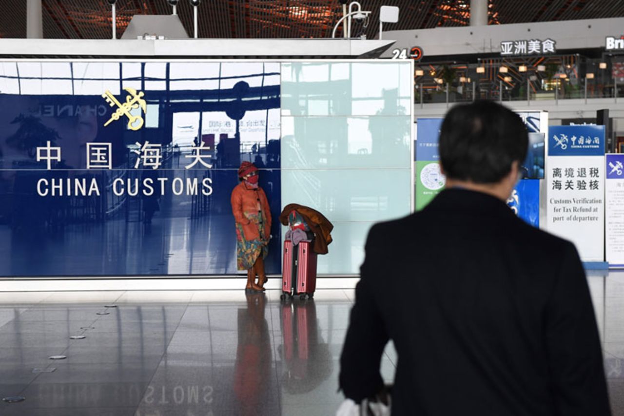 A woman wears a face mask as a preventive measure against coronavirus as she waits at Beijing Capital Airport in Beijing on March 11. 