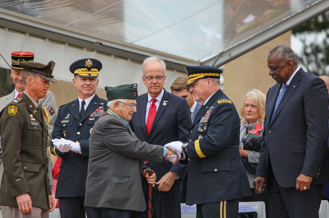 World War II veteran Jack Foy shakes the hand of the then-chairman of the Joint Chiefs of Staff, Gen. Mark A. Milley, at last year's D-Day anniversary.