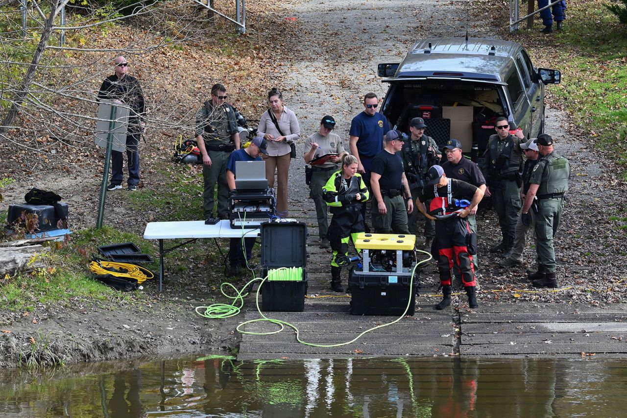 Law enforcement officials prepare to search the Androscoggin River in Lisbon, Maine, on Friday.