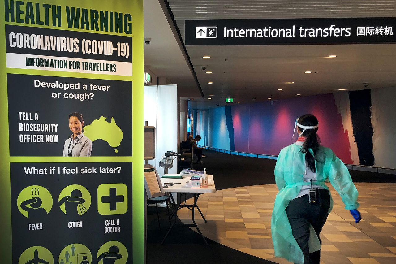 A staff member in protective medical clothing moves through the arrivals area at Brisbane International Airport on March 16 in Brisbane, Australia.