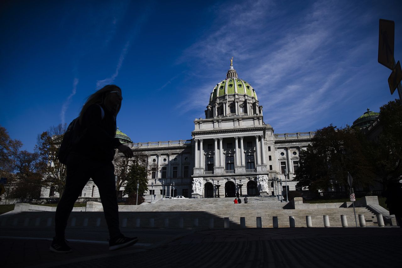 In this file photo from Nov. 19, 2019, a person is silhouetted in the shade as he walks by the Pennsylvania Capitol in Harrisburg, Pennsylvania.