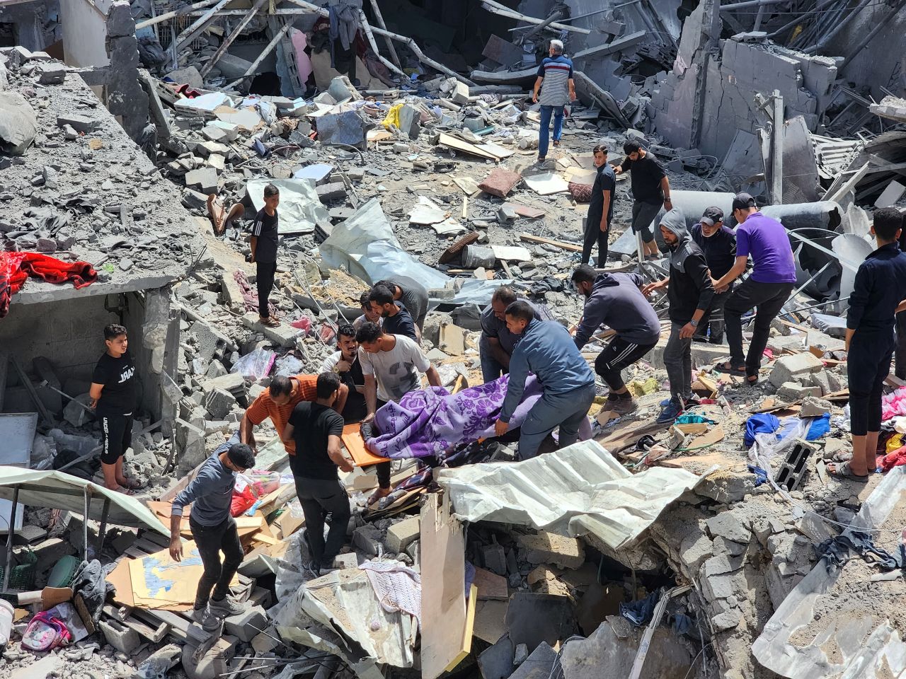 People carry the body of a person killed by an Israeli strike on a house in the Jabalya refugee camp in Gaza on May 18.
