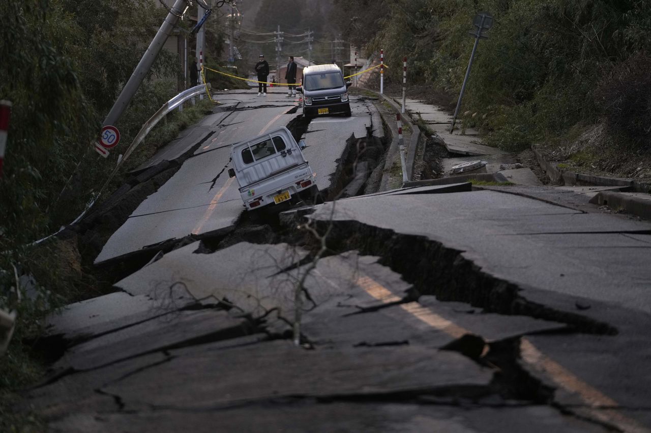 Bystanders view damage to a road near Noto, Japan, on Tuesday, Januar 2.