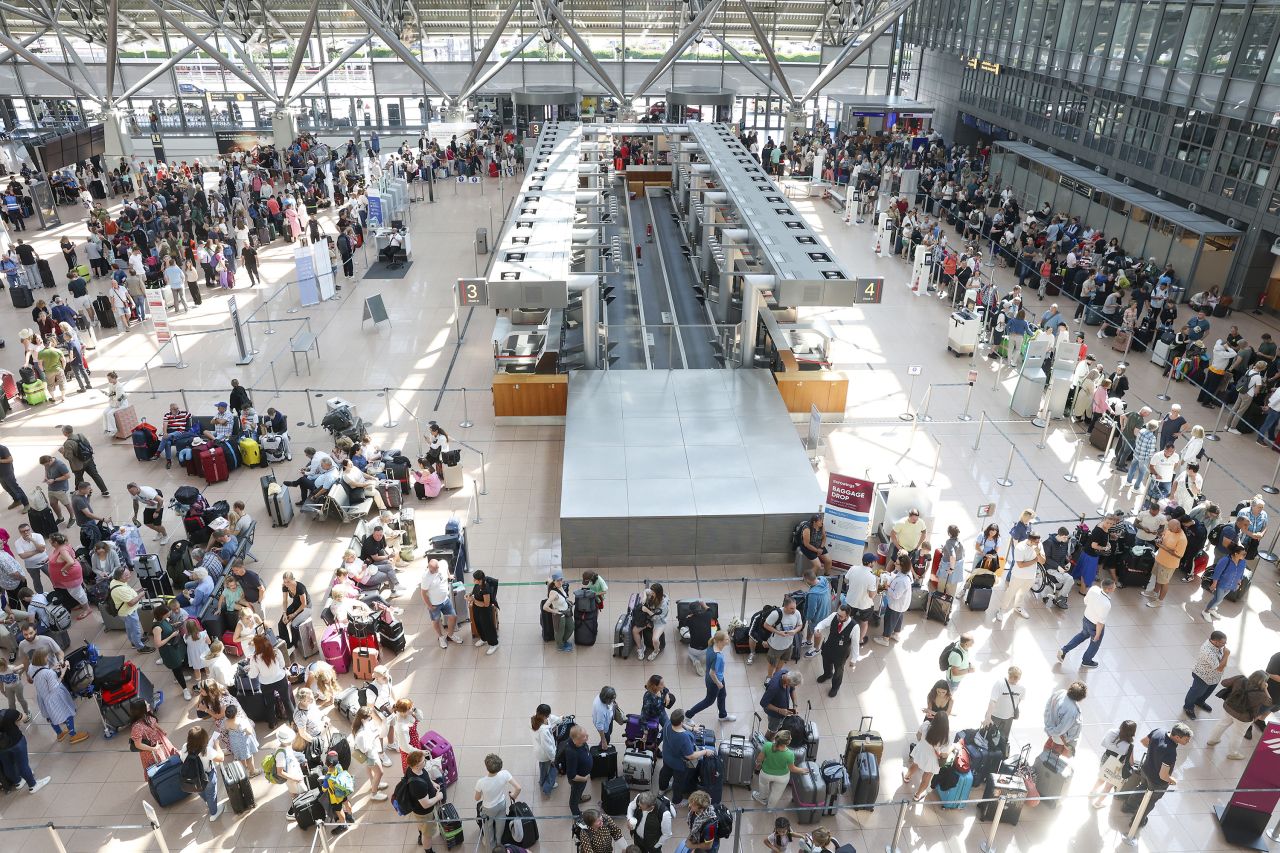 Travelers wait in Terminal 1 for check-in at Hamburg Airport in Germany on July 19.