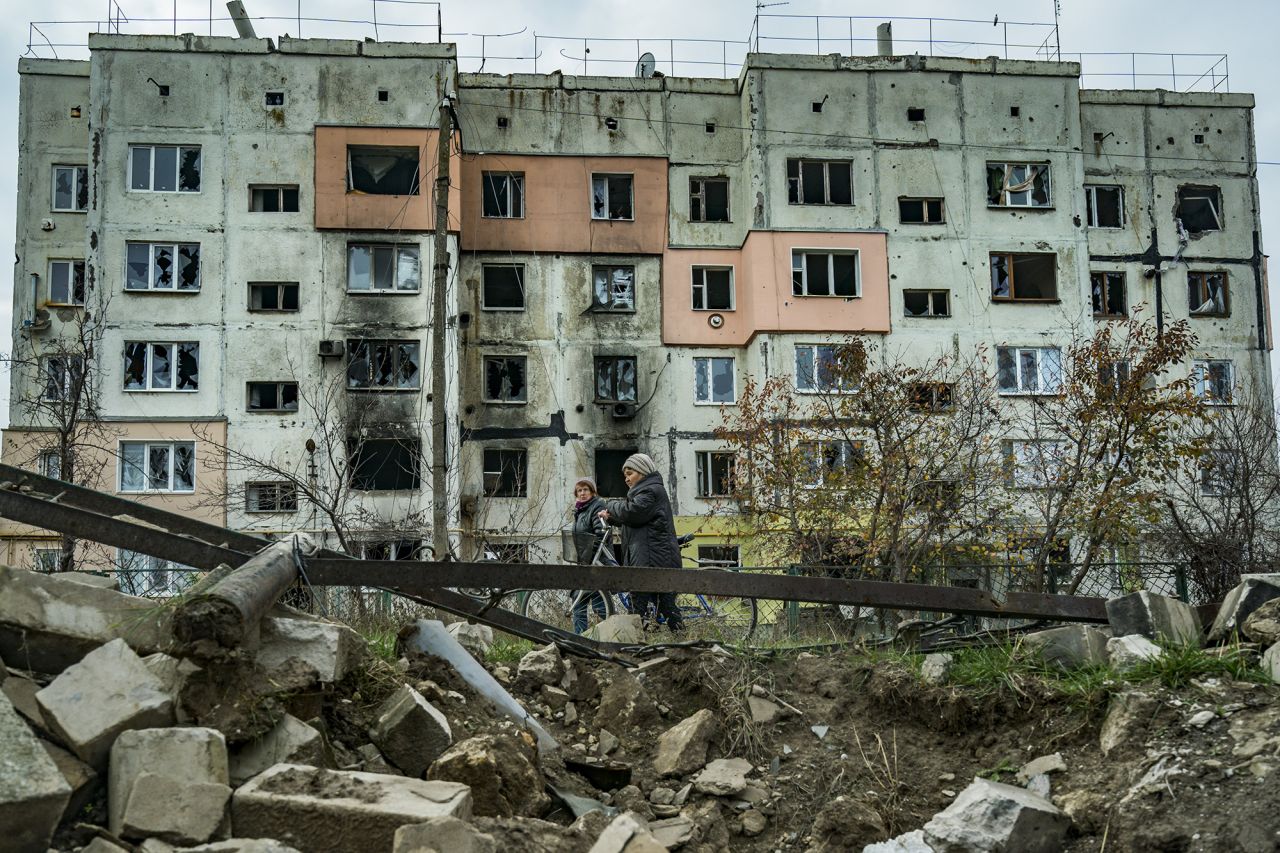A couple of women walk past a destroyed building in Arkhanhelske, Kherson, after the recent withdrawal of Russian troops, November 9.