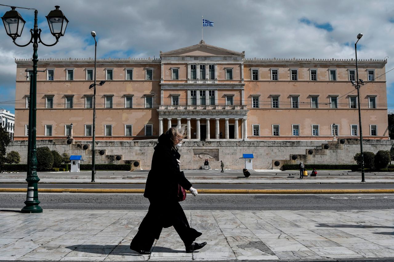 A woman walks past the empty Syntagma Square in Athens, Greece, on March 16.