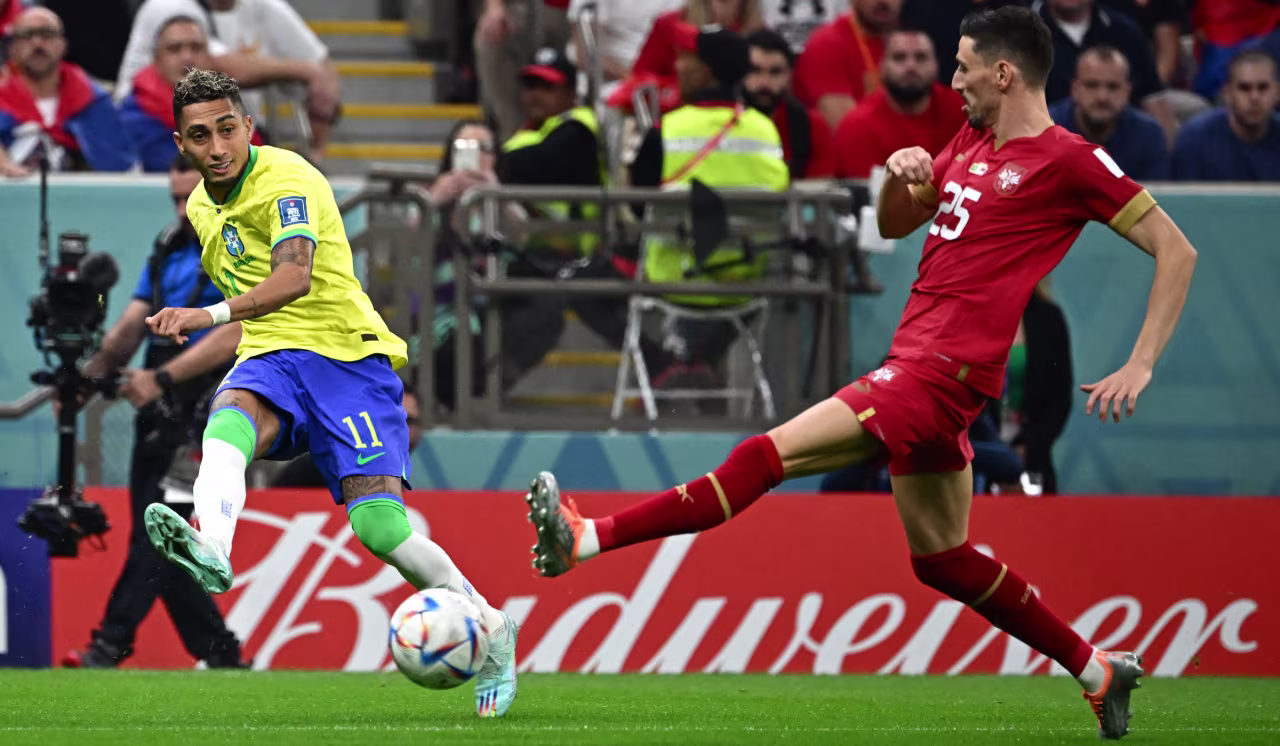 Brazil's Raphinha, left, makes a pass next to Serbian defender Filip Mladenovic during their match on Thursday.
