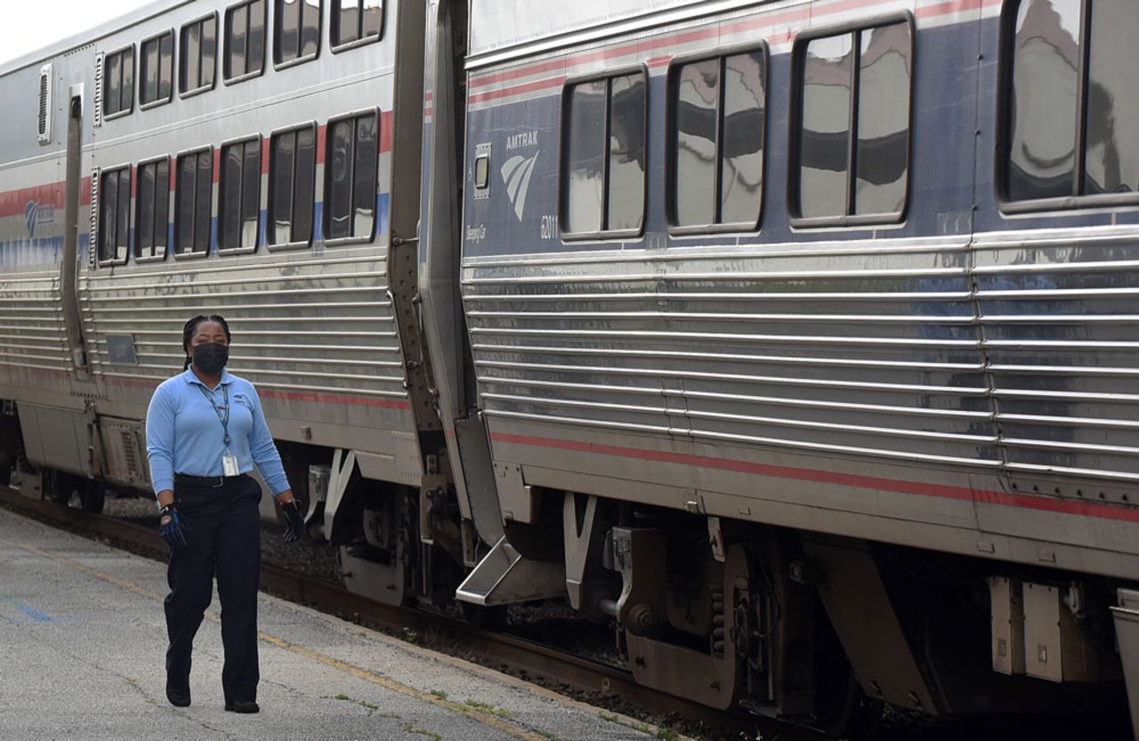 An Amtrak employee wearing a protective face mask walks alongside a nearly empty southbound Amtrak train as it arrives on April 15 in Orlando, Florida.