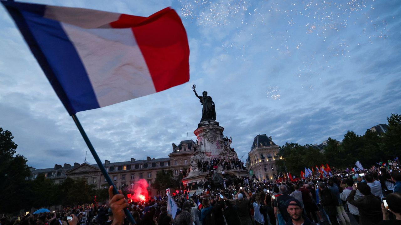 Crowds gather during a nighttime election rally at Place de la République in Paris. 