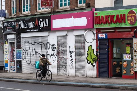 A person rides past some closed restaurants in London on February 1.