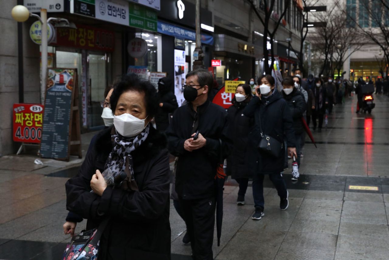 People wearing masks to prevent the spread of coronavirus line up to buy face masks at a department store on February 28, 2020 in Seoul, South Korea. 