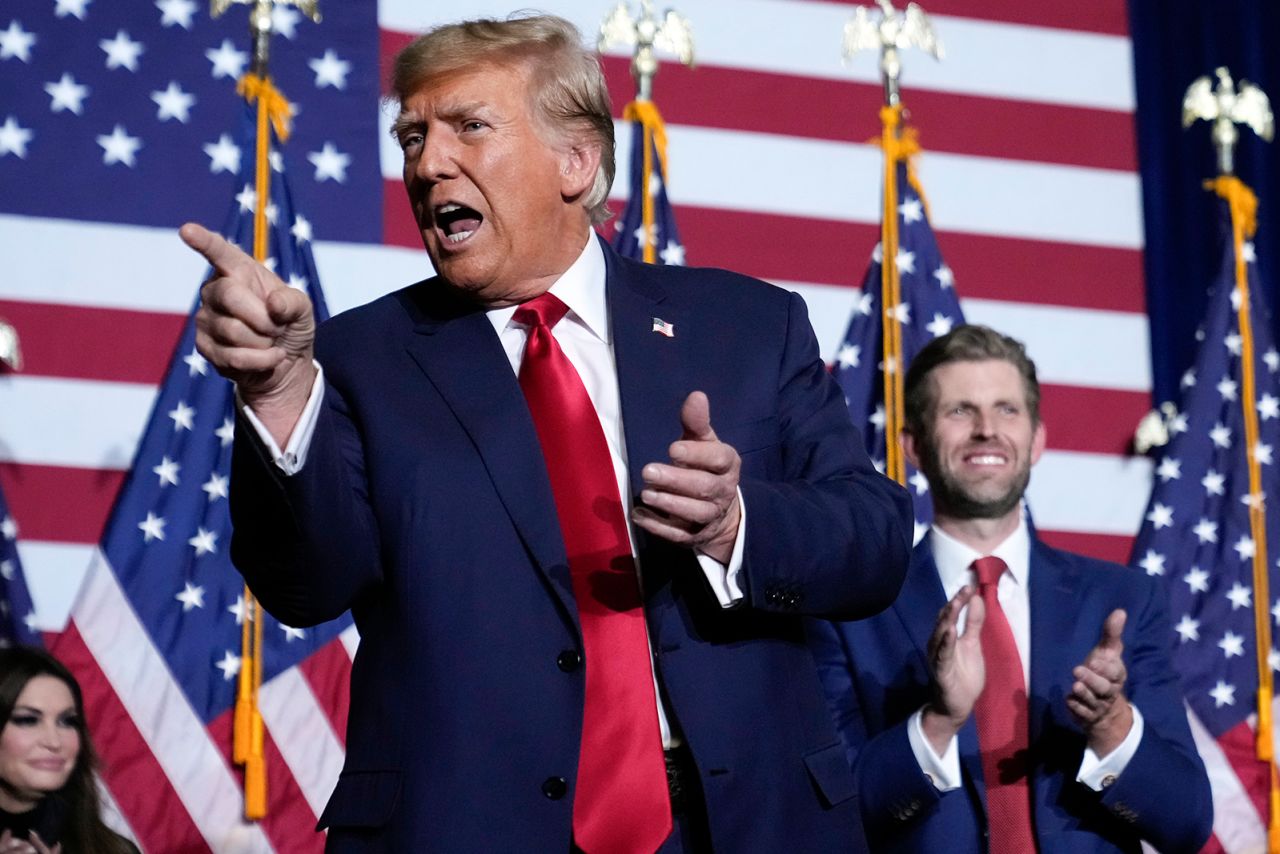 Donald Trump points to the crowd, accompanied by his son, Eric, at a caucus night party in Des Moines, Iowa, January 15.