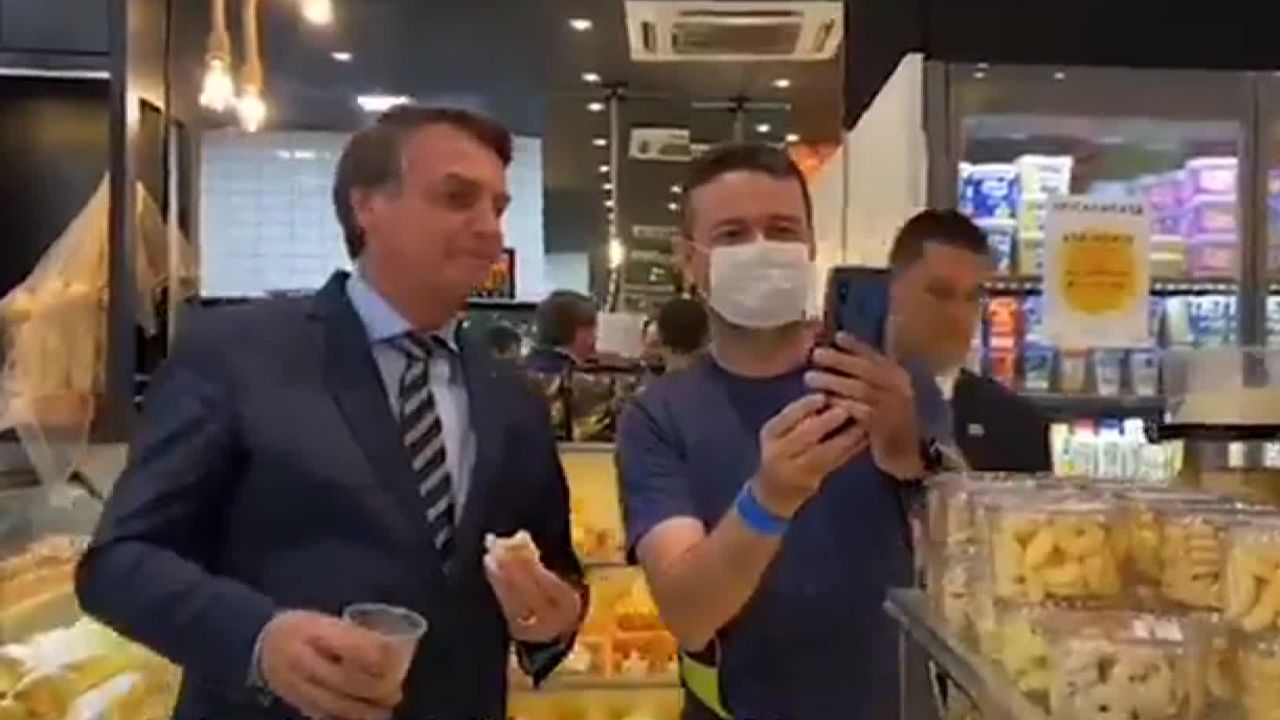 Brazilian President Jair Bolsonaro, left, poses for a photo while visiting a local bakery.