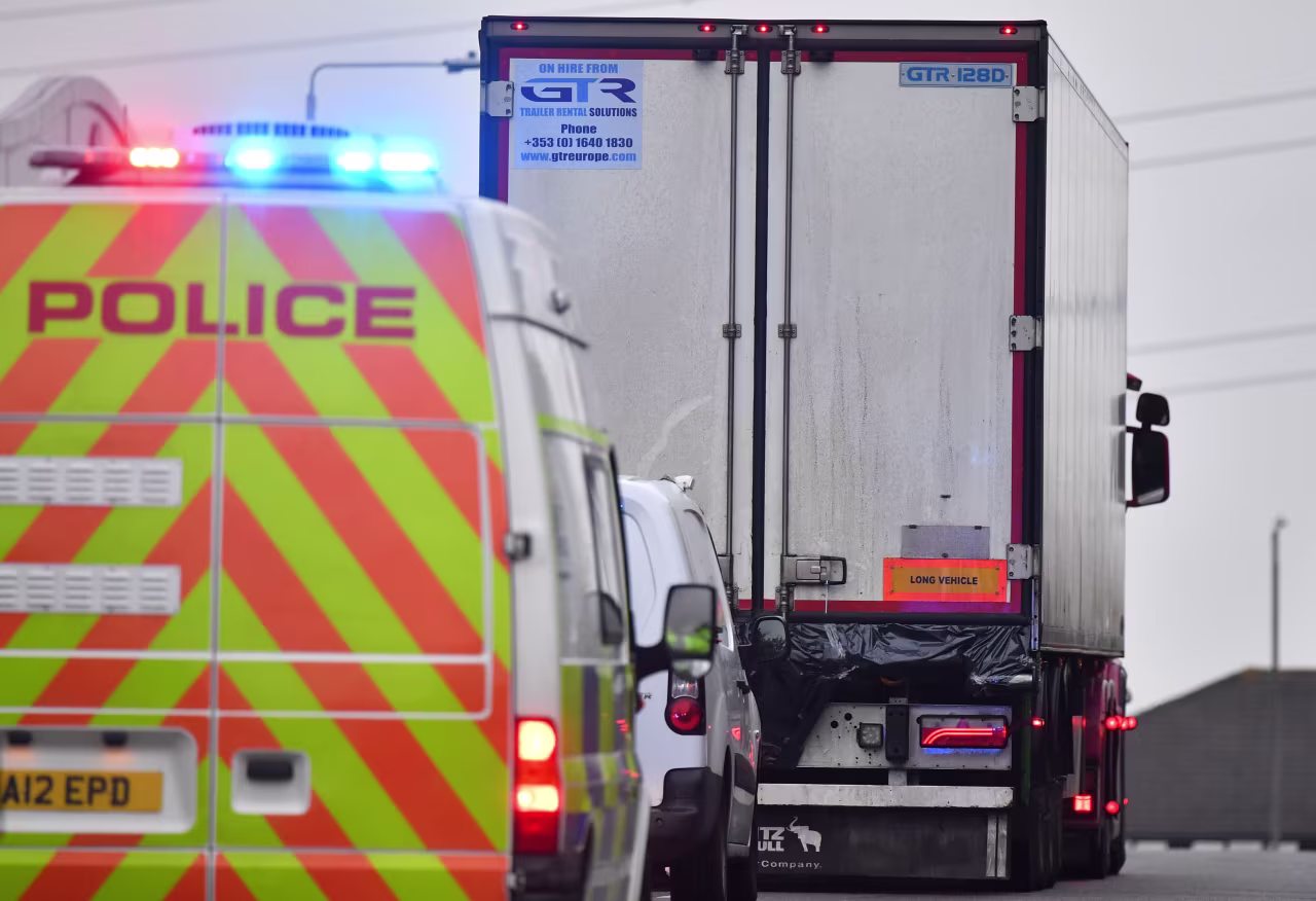 Police officers drive away a lorry from Waterglade Industrial Park on October 23.