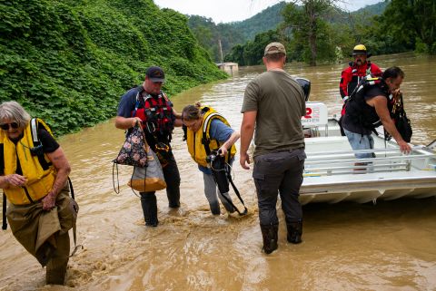 Members of a rescue team assist a family out of a boat on July 28, in Quicksand, Kentucky.