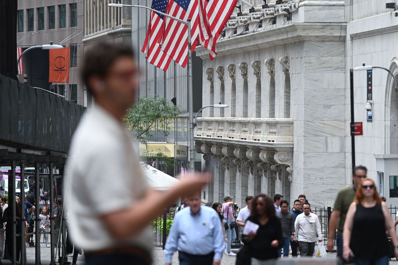 People walk past the New York Stock Exchange on July 24.