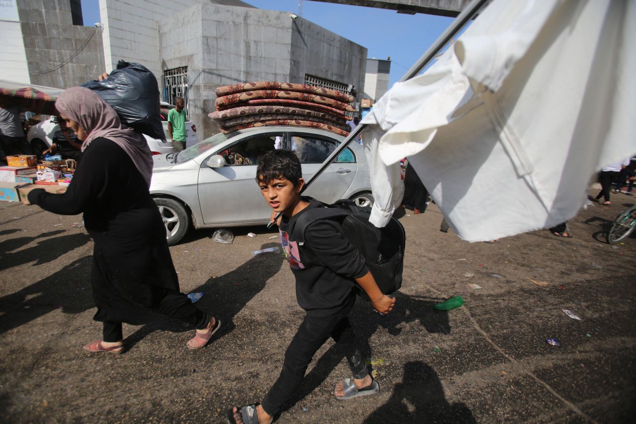 A Palestinian boy carries a make-shift white flag as he arrives with his mother near the Al-Shifa hospital in Gaza City on November 6.