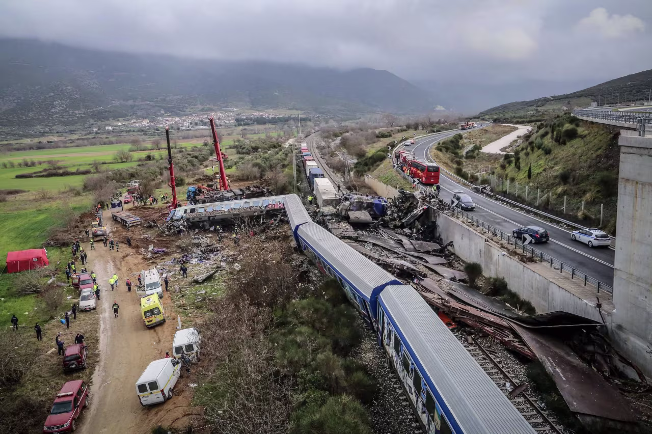 Police and emergency crews search the debris of a crushed wagon after a train crash near Larissa on Wednesday morning.