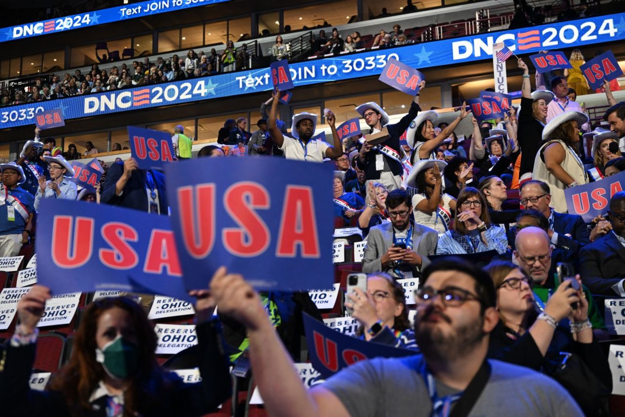 People hold USA signs at the start of the convention.