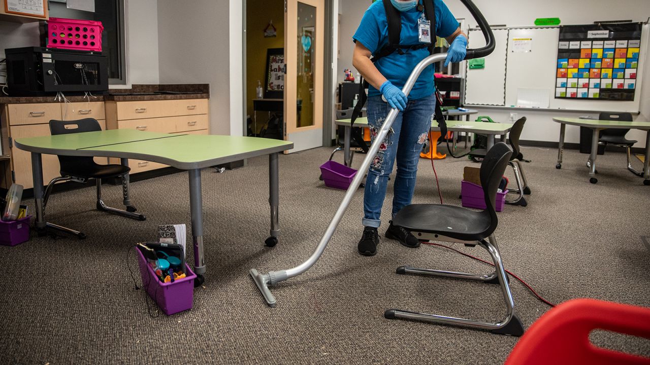 A custodial worker vacuums a classroom at an elementary school in Leander, Texas, on Friday, September 18, 2020.