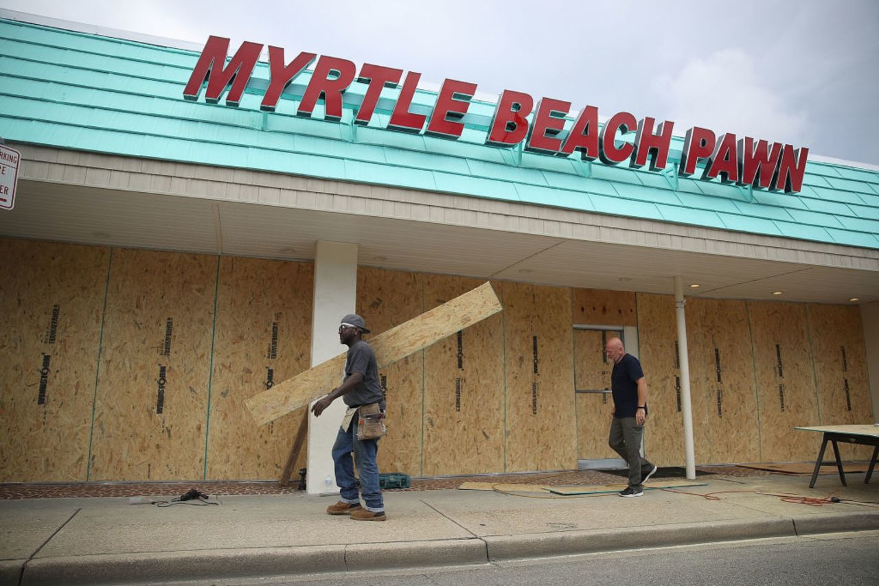 Jeff Bryant (L) and James Evans board the windows of a business ahead of the arrival of Hurricane Florence on Sept. 11, 2018 in Myrtle Beach, South Carolina. 