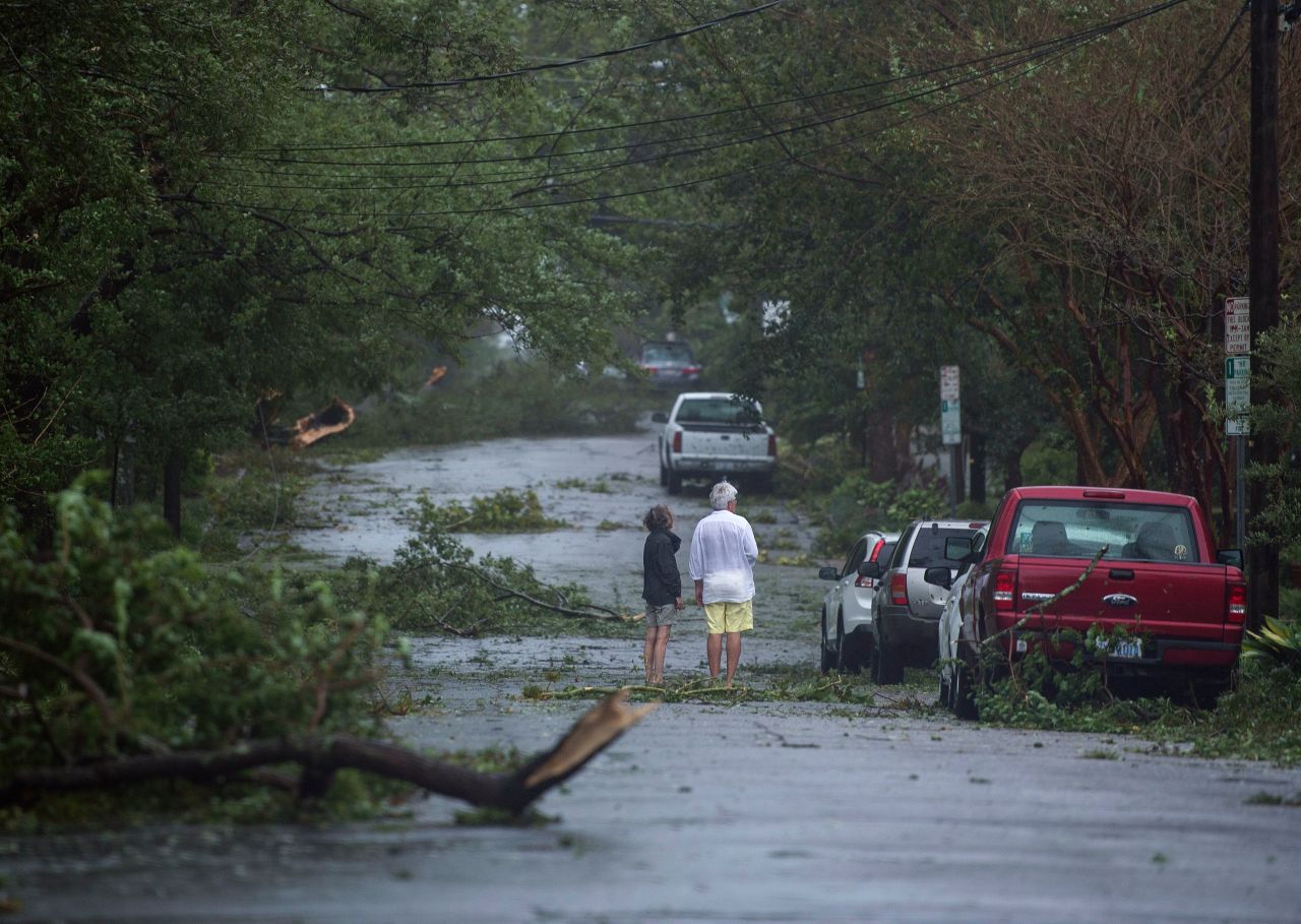 Residents look at downed tree as Hurricane Florence passes over Wilmington, North Carolina, Friday 