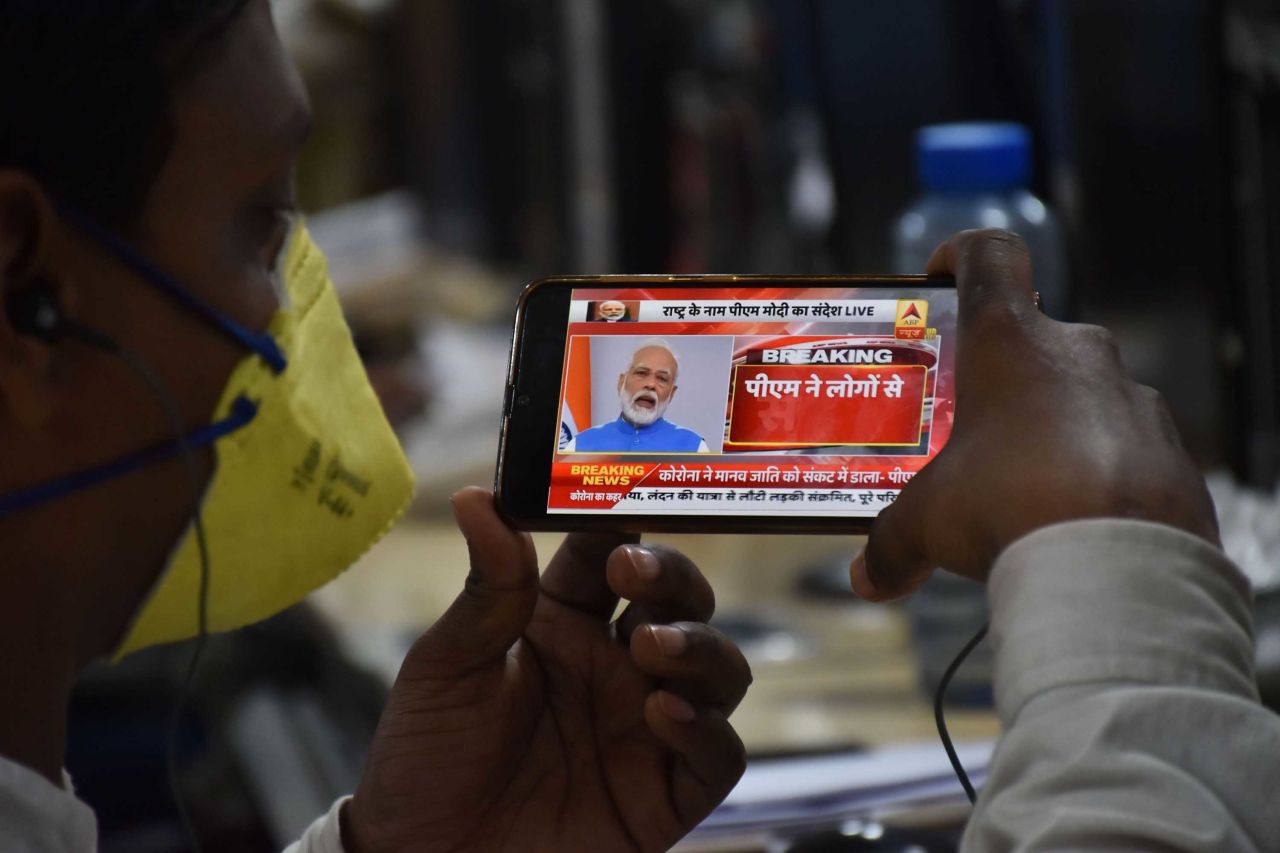 A man watches Indian Prime Minister Narendra Modi's address to the nation on a mobile phone in Jabalpur, on March 19.