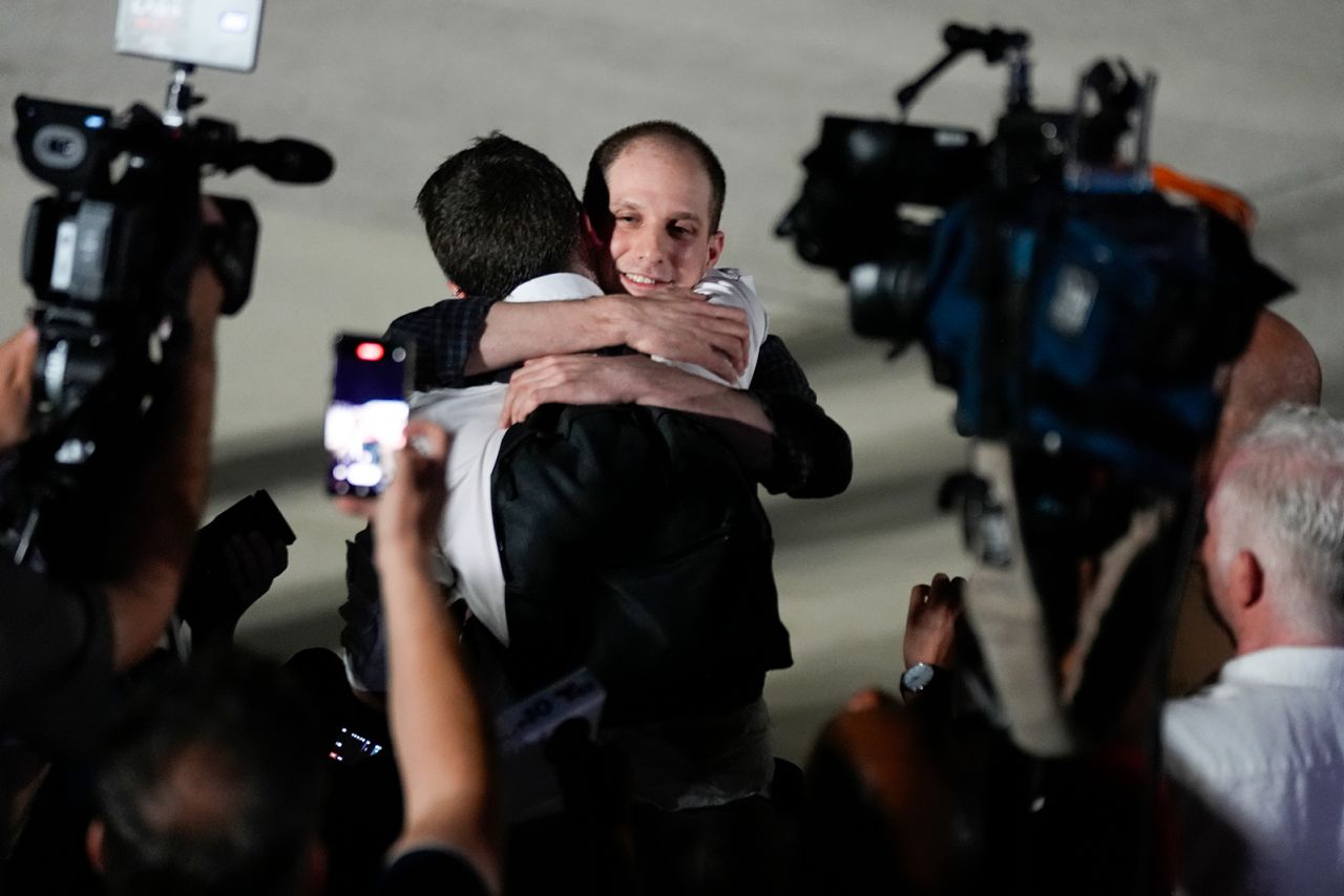 Reporter Evan Gershkovich receives an embrace following his release as part of a 24-person prisoner swap between Russia and the United States on Thursday.