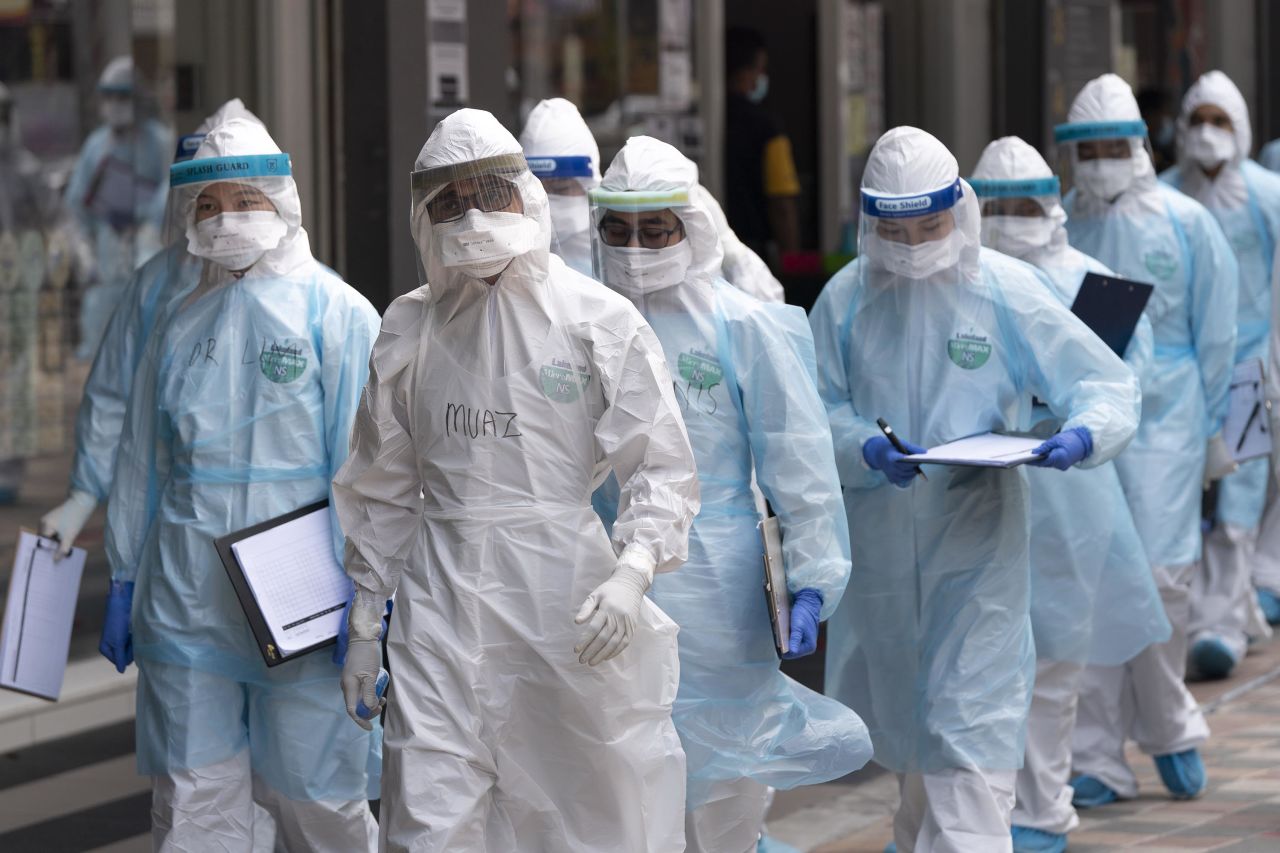 Medical workers enter a building under lockdown in Kuala Lumpur, Malaysia, on April 7.