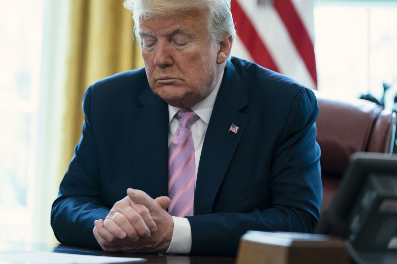 President Donald Trump prays during an Easter blessing event in the Oval Office of the White House on April 10.