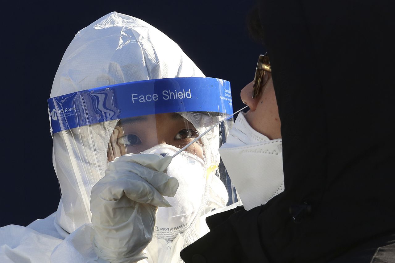 A medical worker takes samples from a man during a Covid-19 testing at a makeshift clinic in Seoul, South Korea, on Monday, December 14.