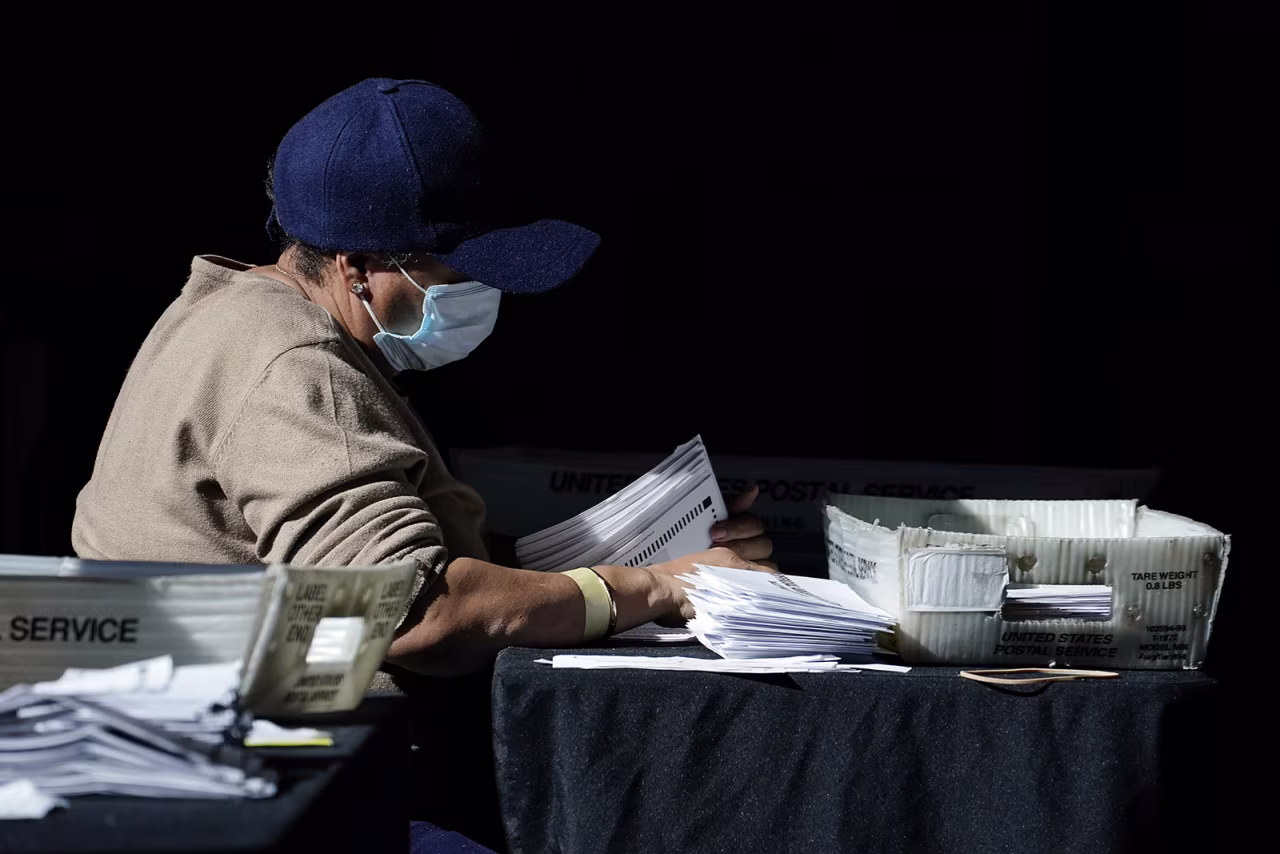 Election personnel examines a ballot as vote counting in the general election continues at State Farm Arena, on Wednesday, November 4, in Atlanta. 