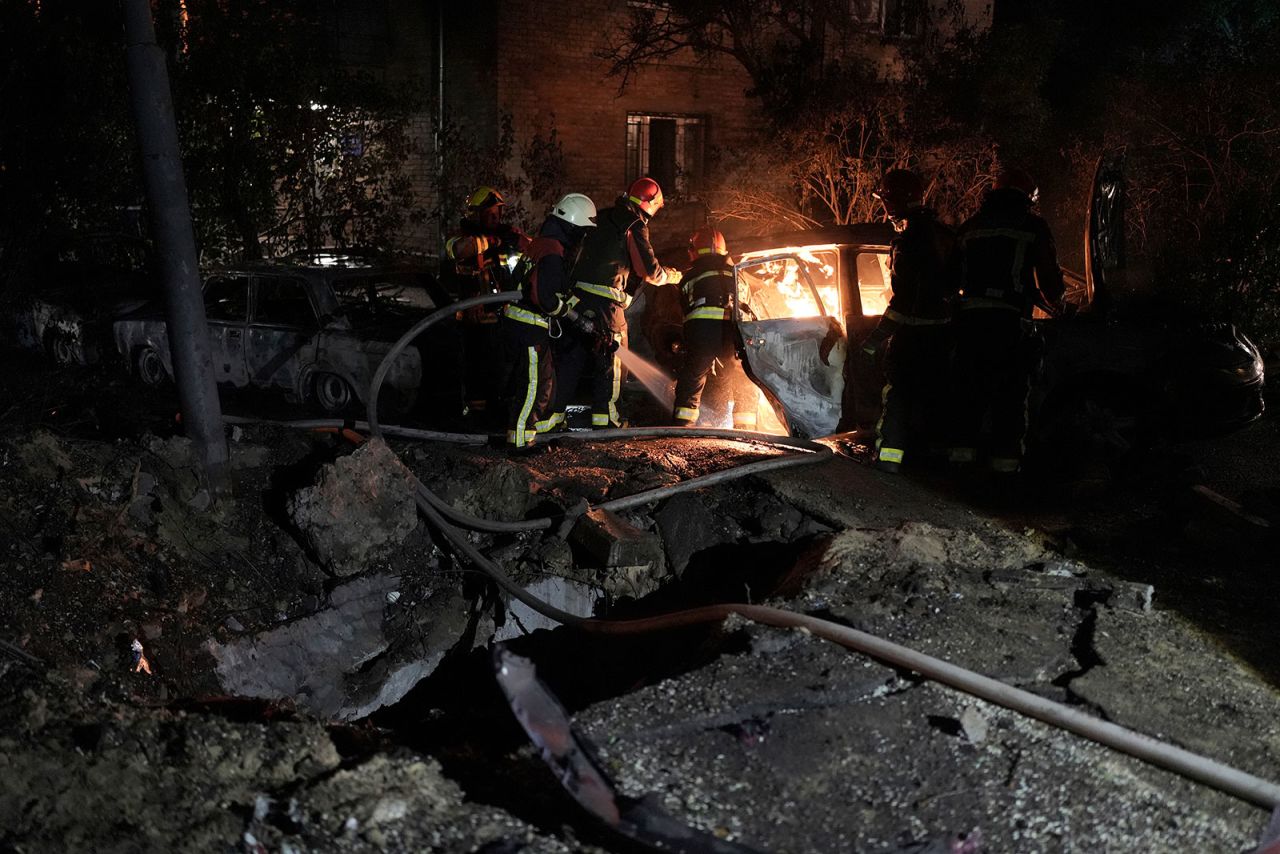 Emergency workers extinguish a fire in a parked car caused by falling debris from an aerial  attack in Kyiv, Ukraine, on Tuesday, May 30.