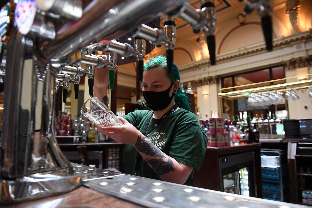 A bar worker prepares customers' drinks at a re-opened Wetherspoons pub in Glasgow on April 26, following the relaxing of some Covid-19 restrictions in Scotland. 