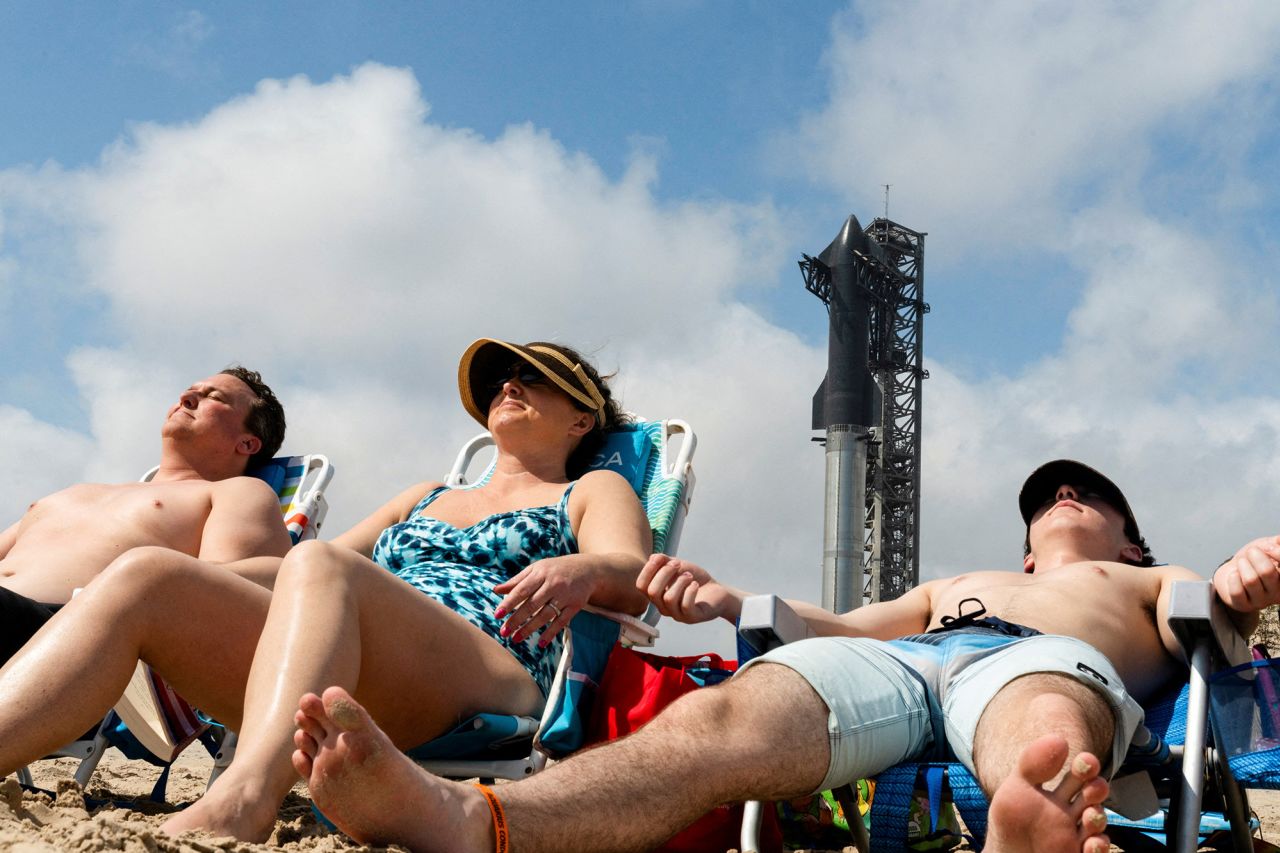 A family from Colorado sun bathes as SpaceX's next-generation Starship spacecraft is prepared for a third launch near Brownsville, Texas, on March 13. 