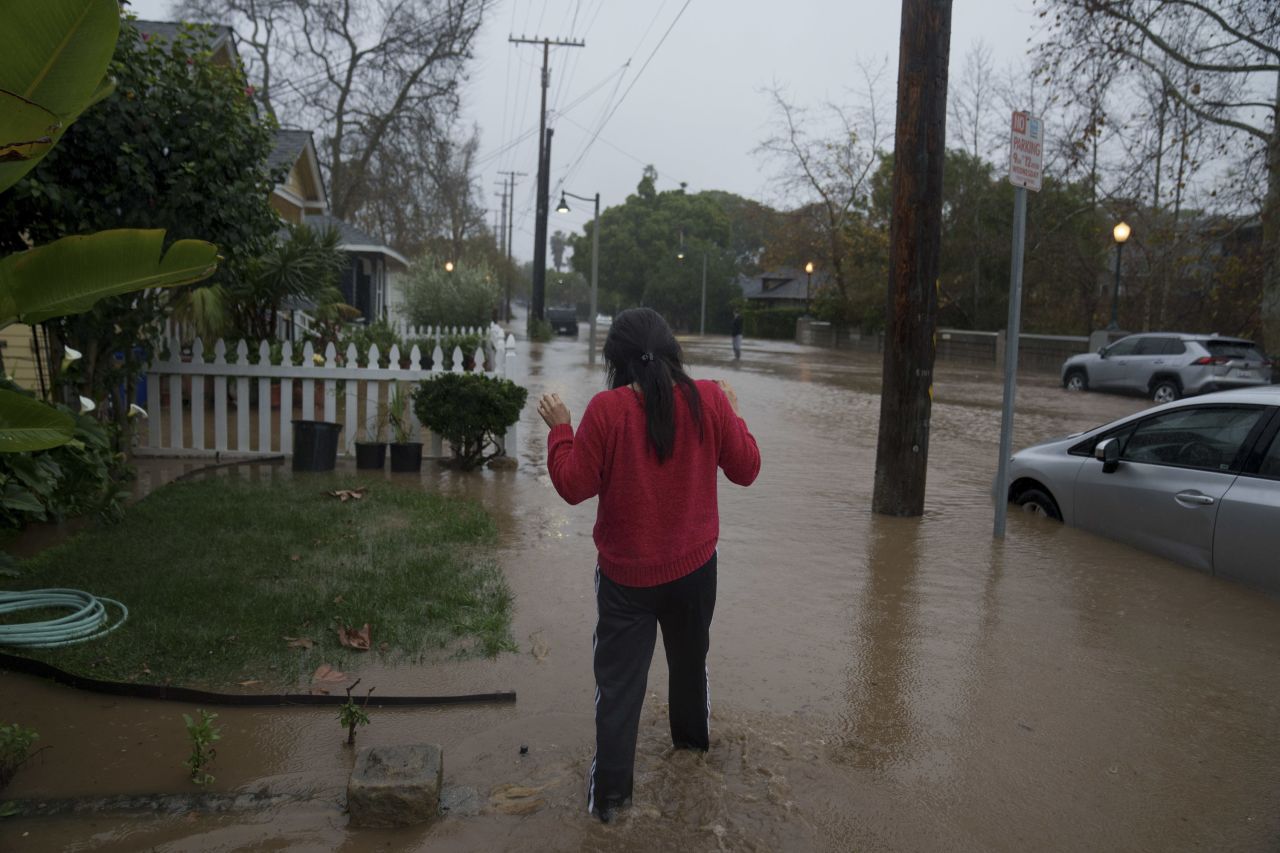 A woman walks through floodwater during a storm in Santa Barbara on Sunday. 