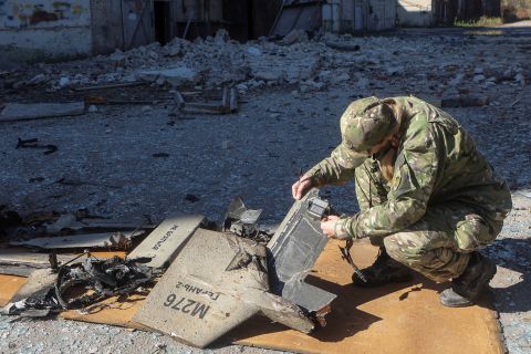 A police officer inspects parts of an unmanned aerial vehicle (UAV), that Ukrainian authorities consider to be an Iranian made suicide drone Shahed-136 on October 6.