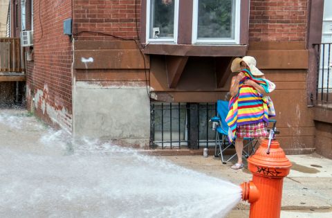 PA woman dries off after cooling down in the spray of a fire hydrant in 2018 in Philadelphia