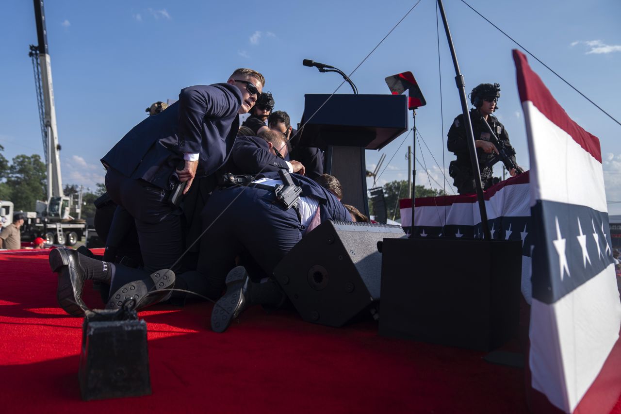 Former President Donald Trump is surrounded by US Secret Service agents after shots were fired at a campaign rally in Butler, Pennsylvania, on Saturday, July 13. 