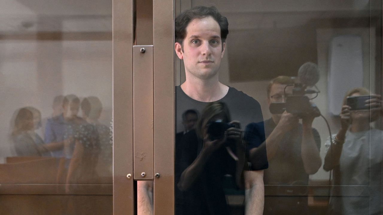 Journalist Evan Gershkovich stands inside a defendants' cage before a hearing in Moscow in June.