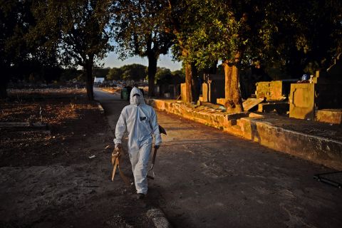 A cemetery worker wearing protective clothing prepares to bury a victim of Covid-19 at the Sao Franciso Xavier cemetery in Rio de Janeiro, Brazil, on May 29.