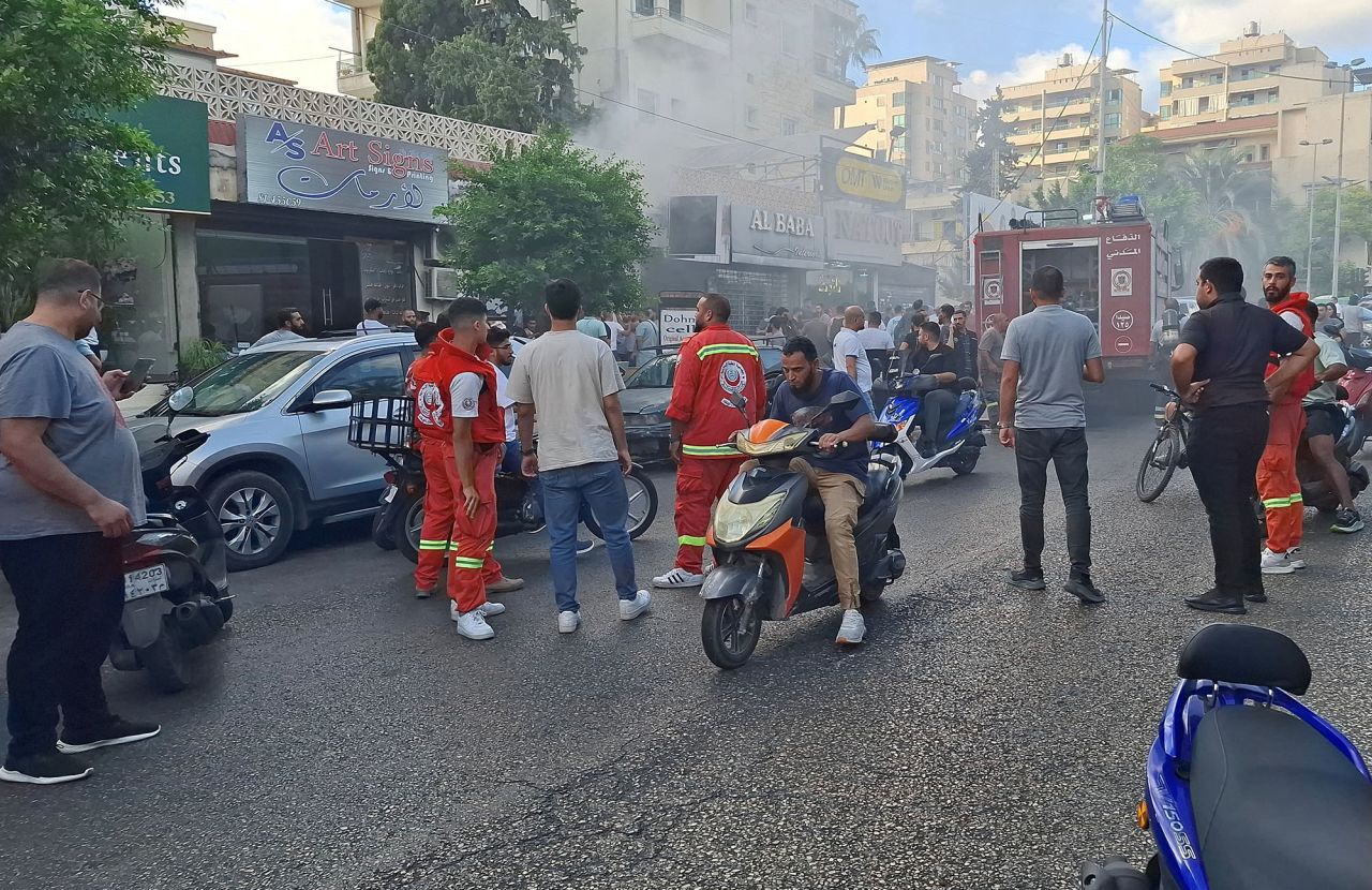 Lübnan'ın Sayda kentinde 18 Eylül'de bir mobil dükkândan dumanlar yükselirken insanlar toplanıyor.