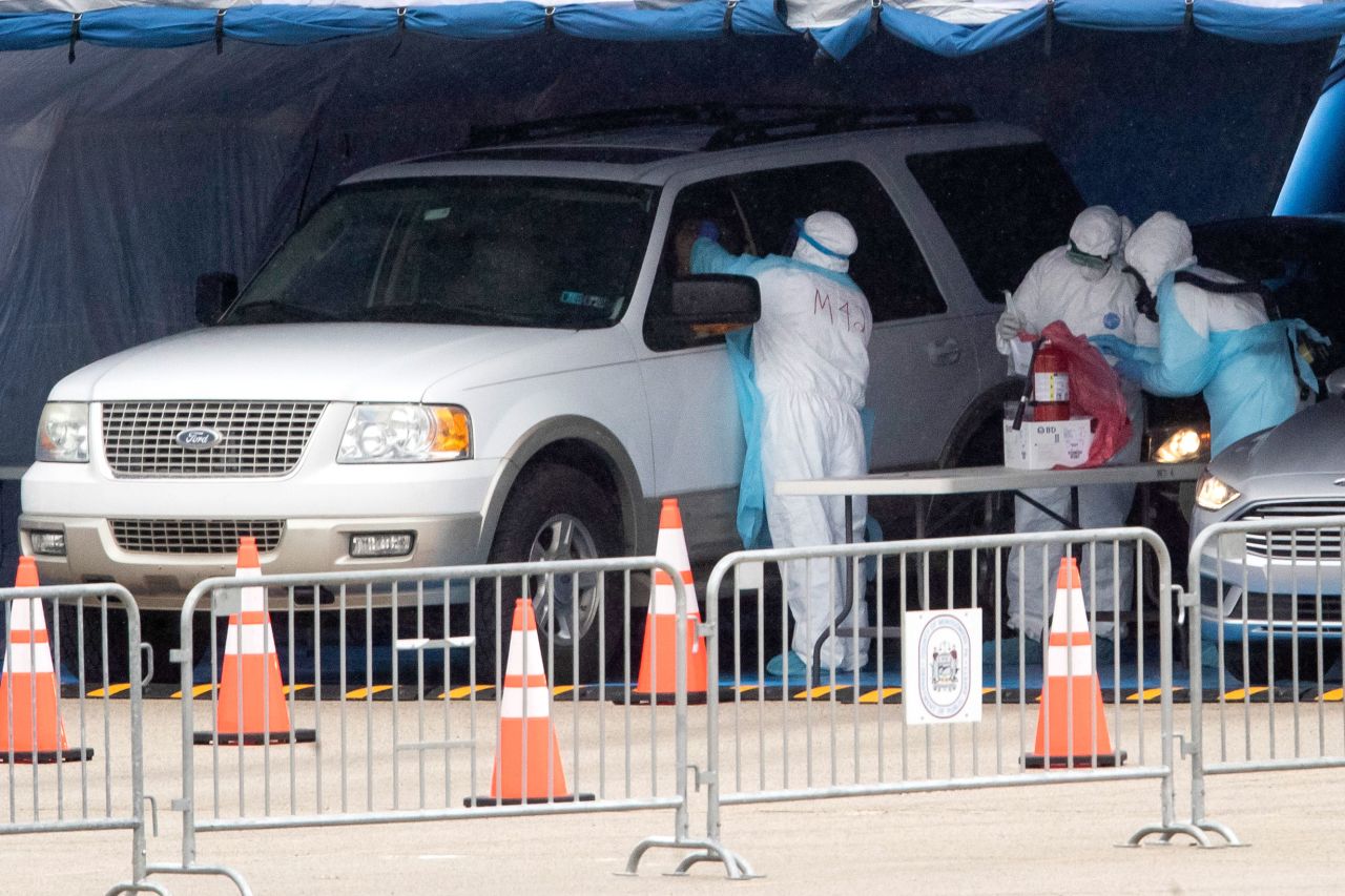 Medical workers perform a coronavirus test on driver at the Temple University Ambler campus in Ambler, Pennsylvania on March 25.