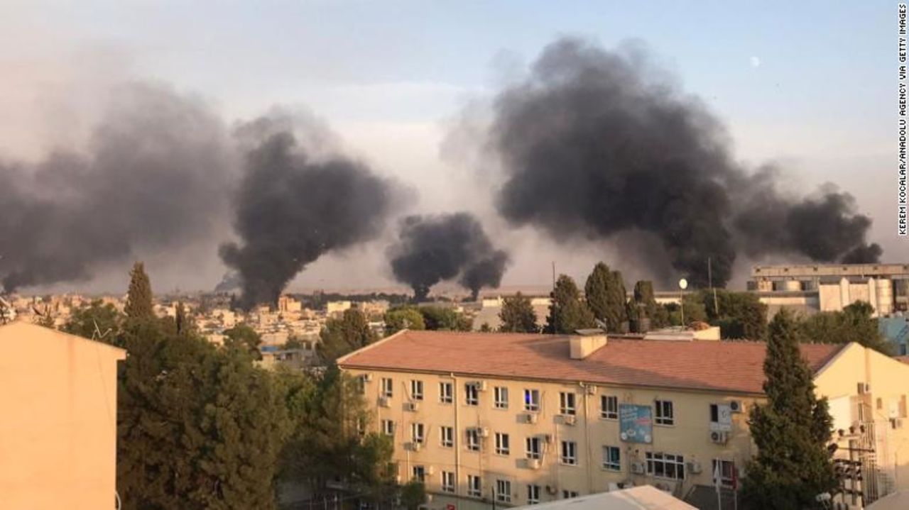 A photo taken from Turkey's Sanliurfa province shows smoke rising over the Syrian town of Ras al-Ayn.