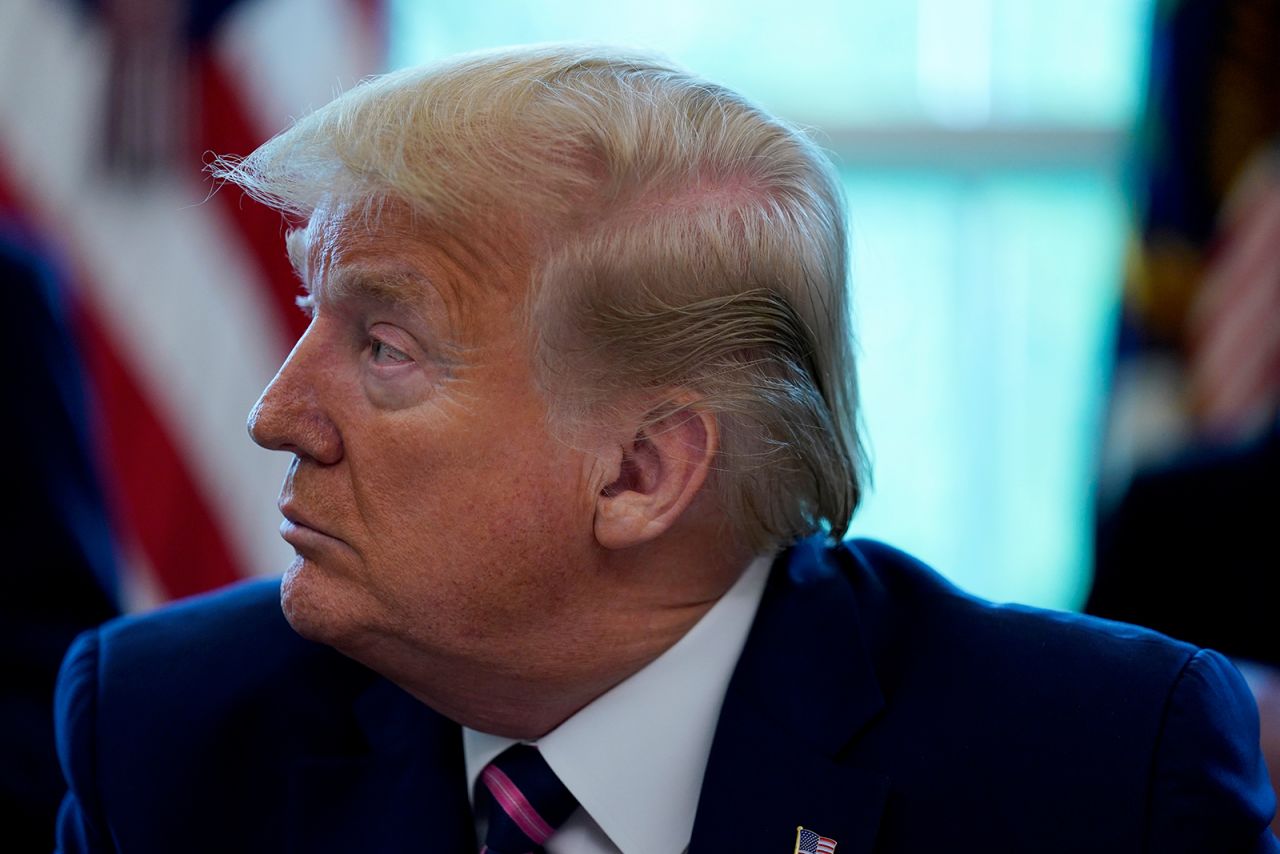 President Donald Trump listens during the signing of a coronavirus aid package in the Oval Office of the White House, April 24.