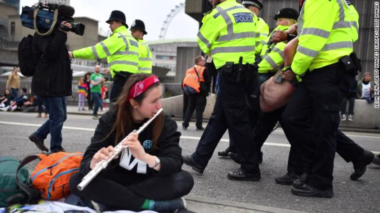 Police officers remove protesters from a blockade on London's Waterloo Bridge during the second day of a coordinated protest by the Extinction Rebellion group on April 16, 2019.